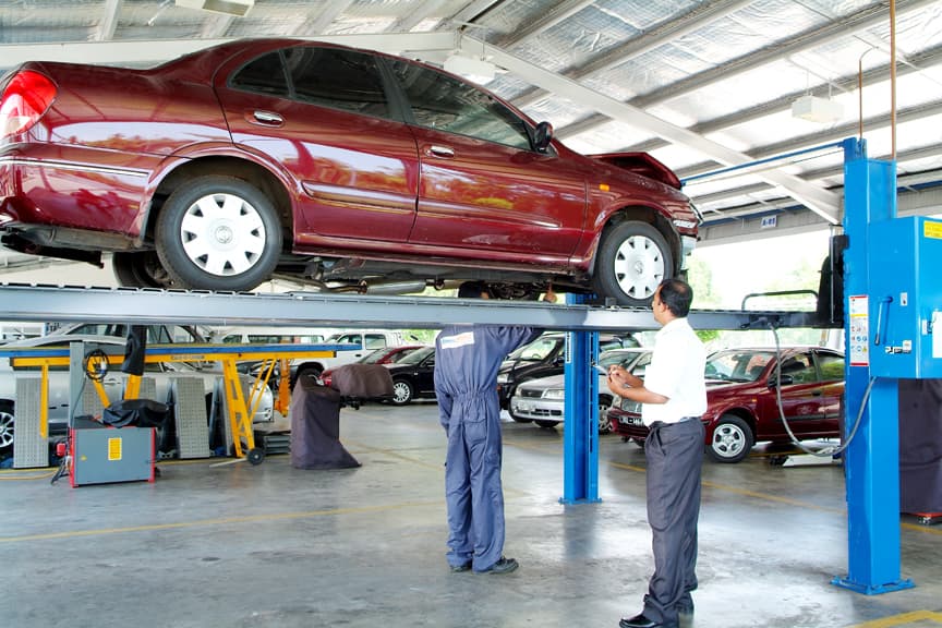 Inspector revisando un coche elevado en la estación